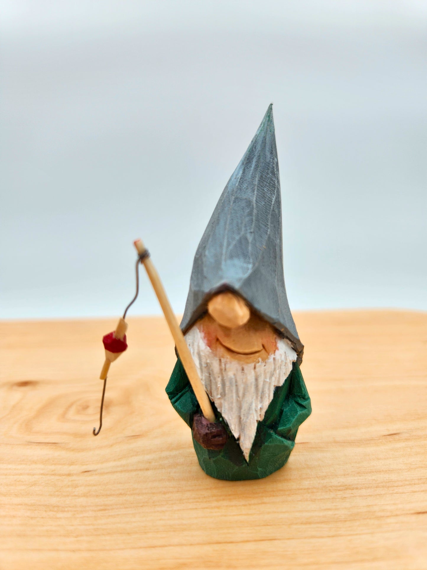 Scandinavian Nisse (Gnome, Wichtel) with grey hat holding fishing rod – handmade wood carving, unik svensk träfigur, perfekt collectible gift for folklore fans, Elfenszene och DIY miniatyrlandskap.