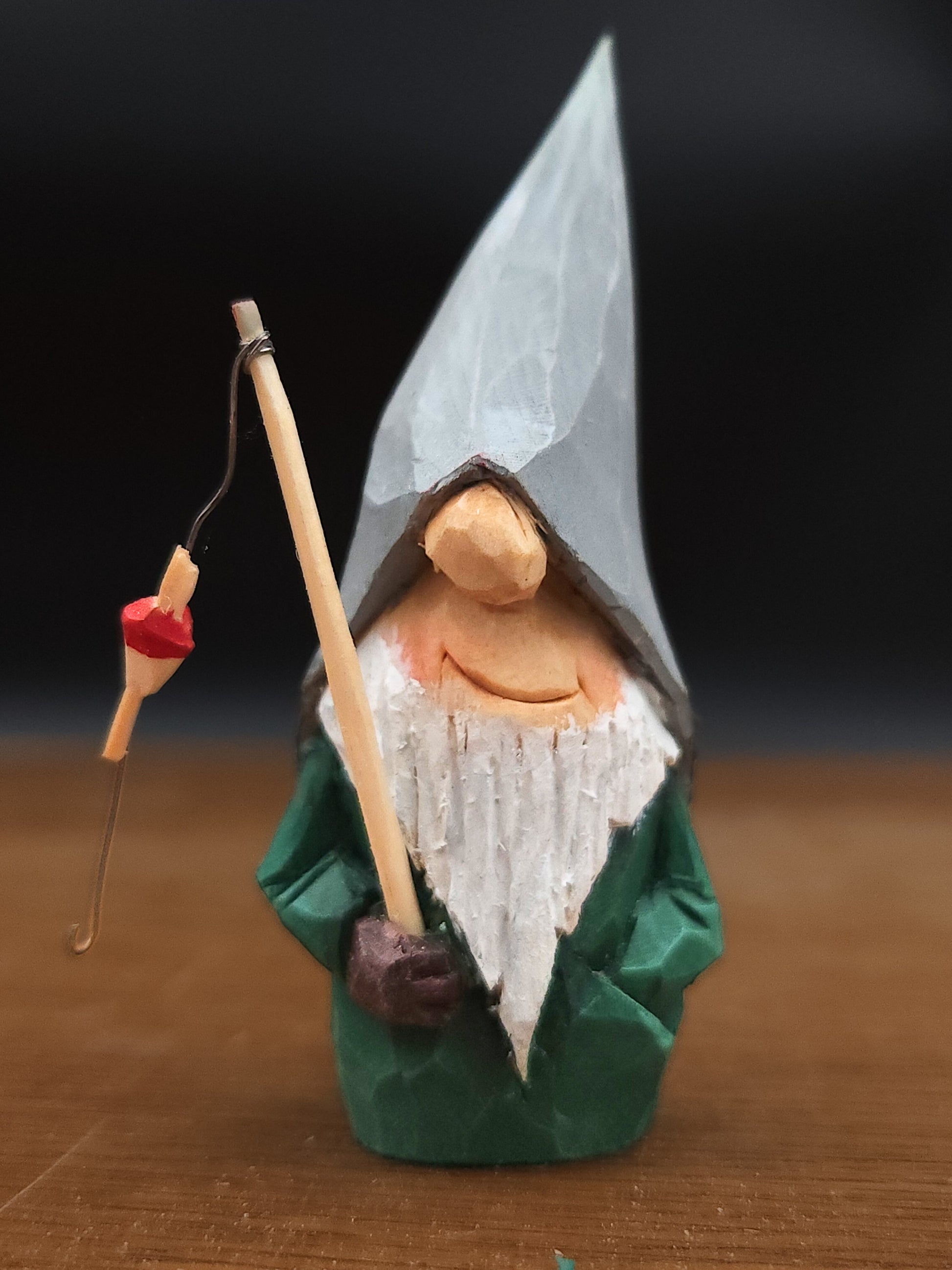 Gift idea – Nisse (Gnome, Wichtel) with grey hat and fishing rod, hand-carved Scandinavian wooden folk art, handgjord svensk träfigur, einzigartiges Sammlerstück för Wichtelwelt, Elfenszene och nordisk miniatyrvärld.
